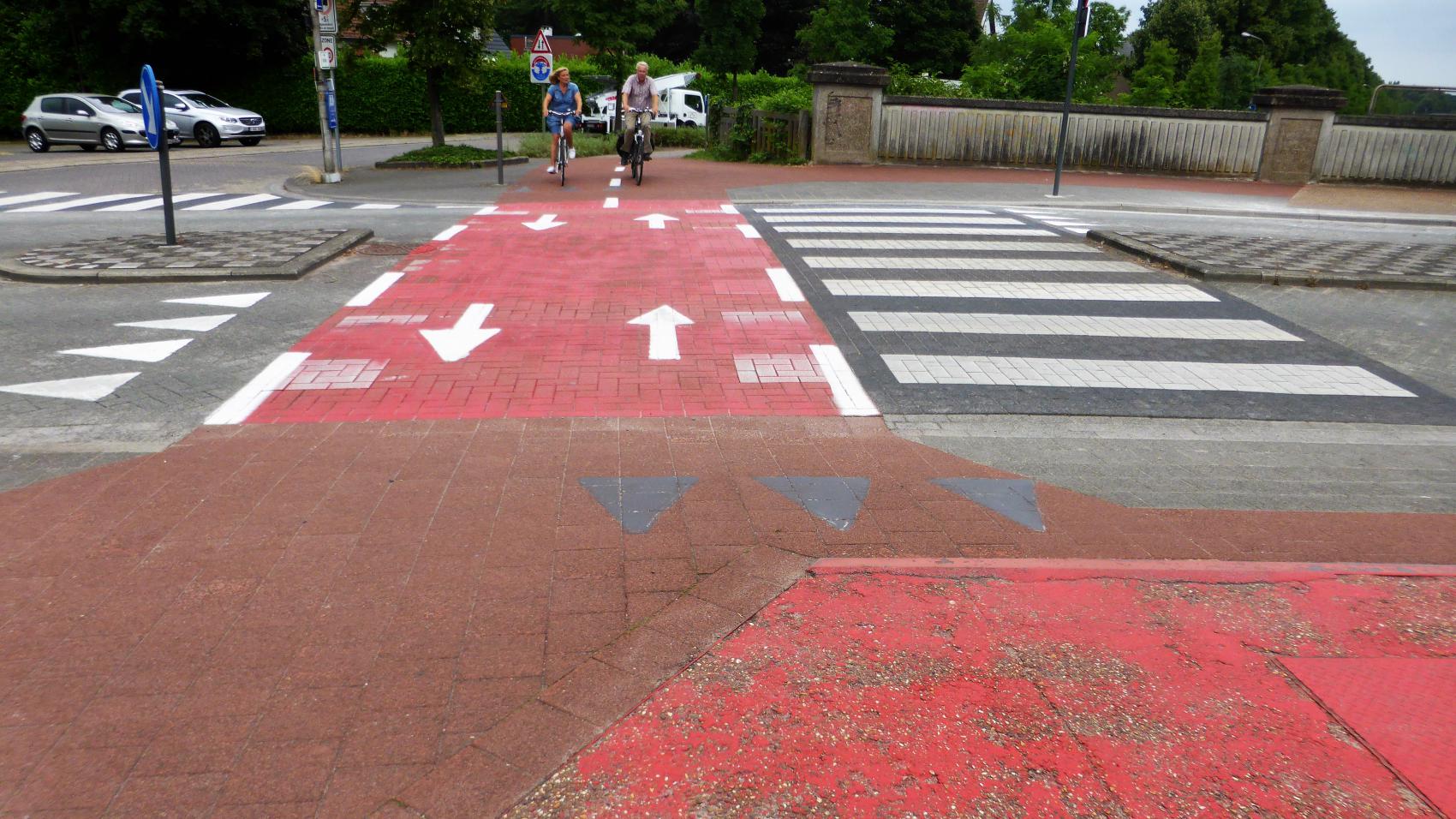 Recently changed priority on the crossing with Deurnestraat in Mortsel. In the past cyclists crossing the carriageway had to give way, now the cycle highway has priority. Old horizontal signs (“shark teeth”) still visible, but greyed out.
