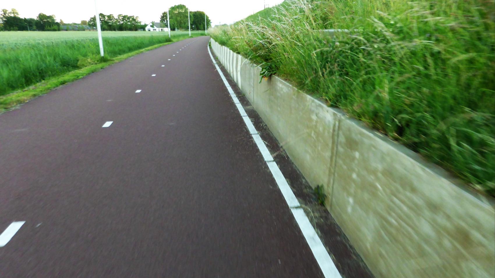 Rare median markings (30 cm line per 3 m) and one-side edge marking to denote the buffer zone and improve the visibility of a low wall. RijnWaalpad cycle highway in Gelderland.  